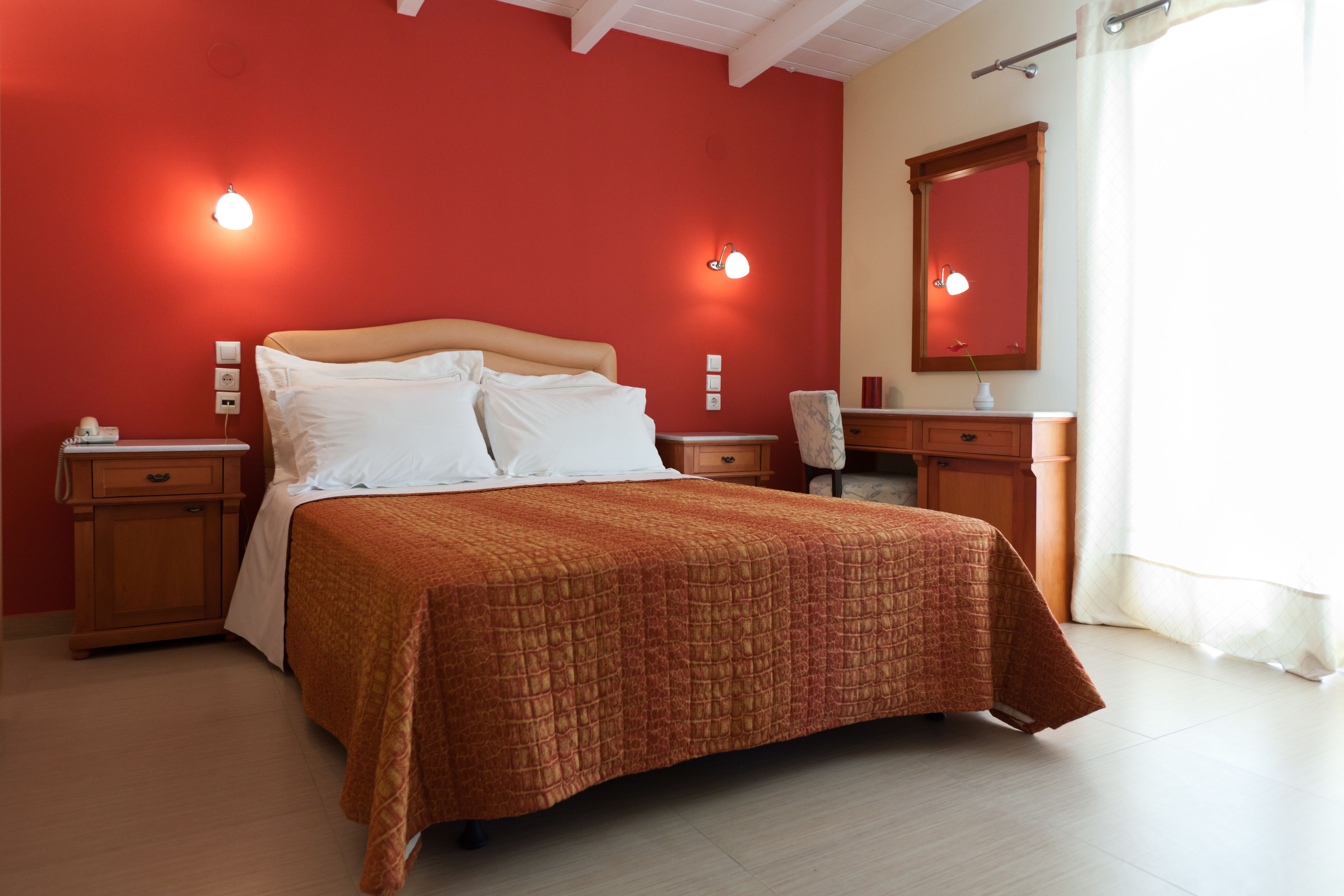 A bedroom with a bed, nightstands, a dresser, and a mirror.