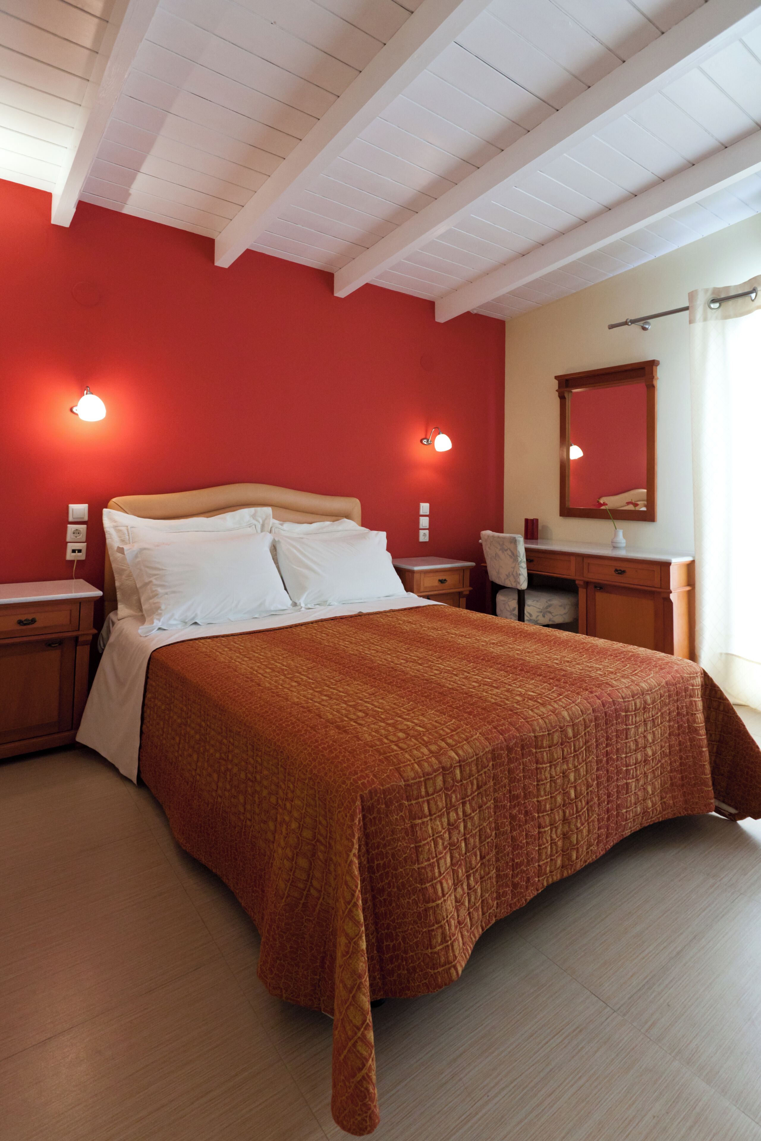 Une chambre à coucher avec un lit, des tables de chevet, un bureau et une chaise.