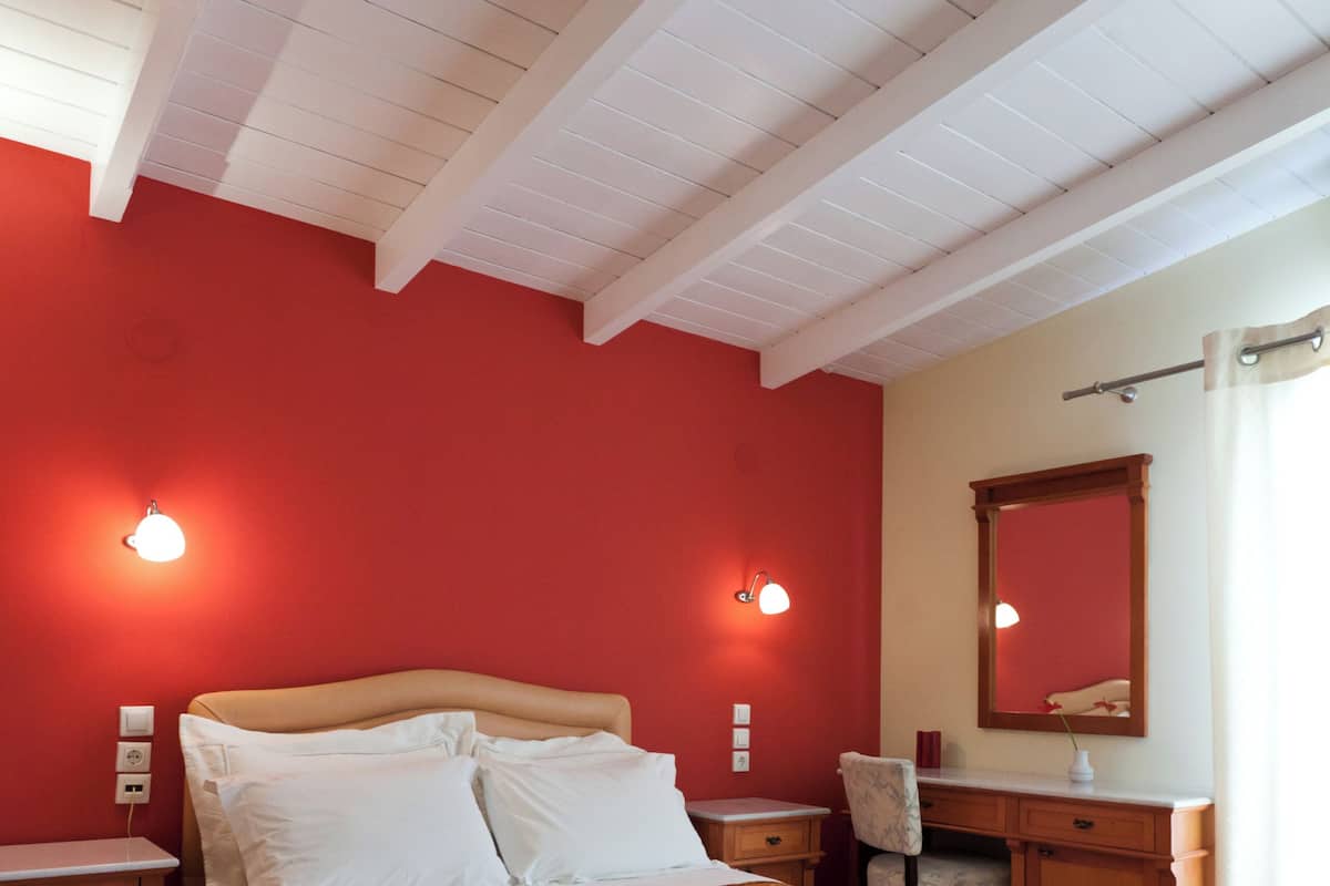 Een slaapkamer met een bed, nachtkastjes, een bureau en een stoel.