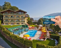 Una piscina al aire libre, sombrillas, sillones reclinables de piscina