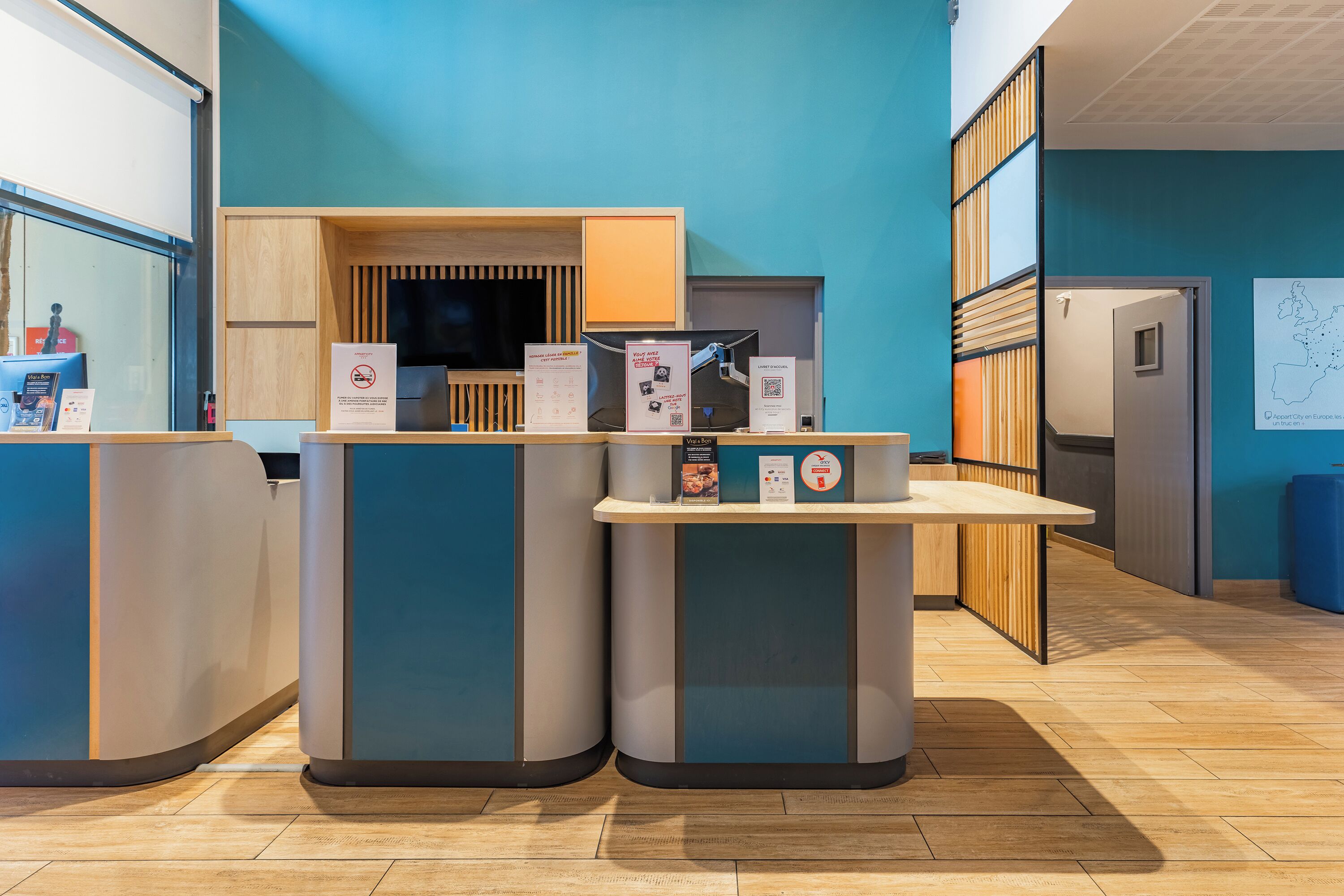 A reception area with a counter, informational signs, and a map on the wall.