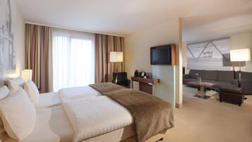 Una habitación de hotel con una cama grande, un escritorio, un televisor y un sofá.