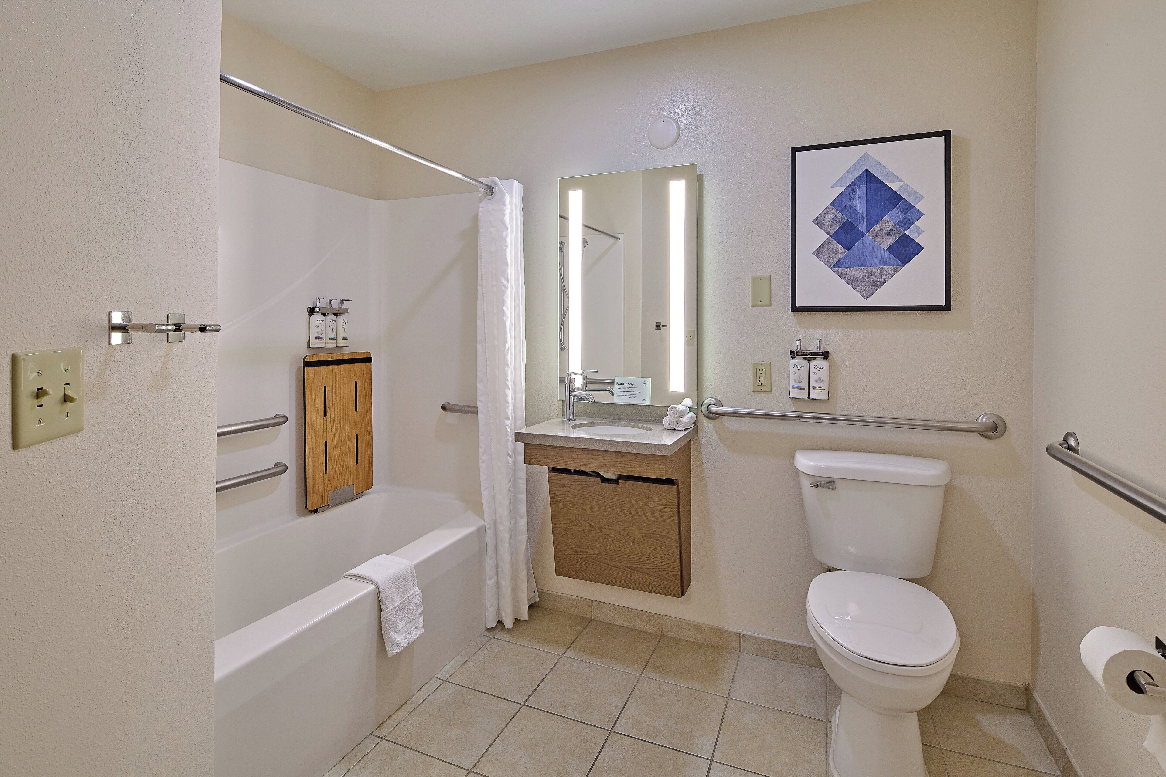 A bathroom with a bathtub, a sink, a toilet, and a mirror.