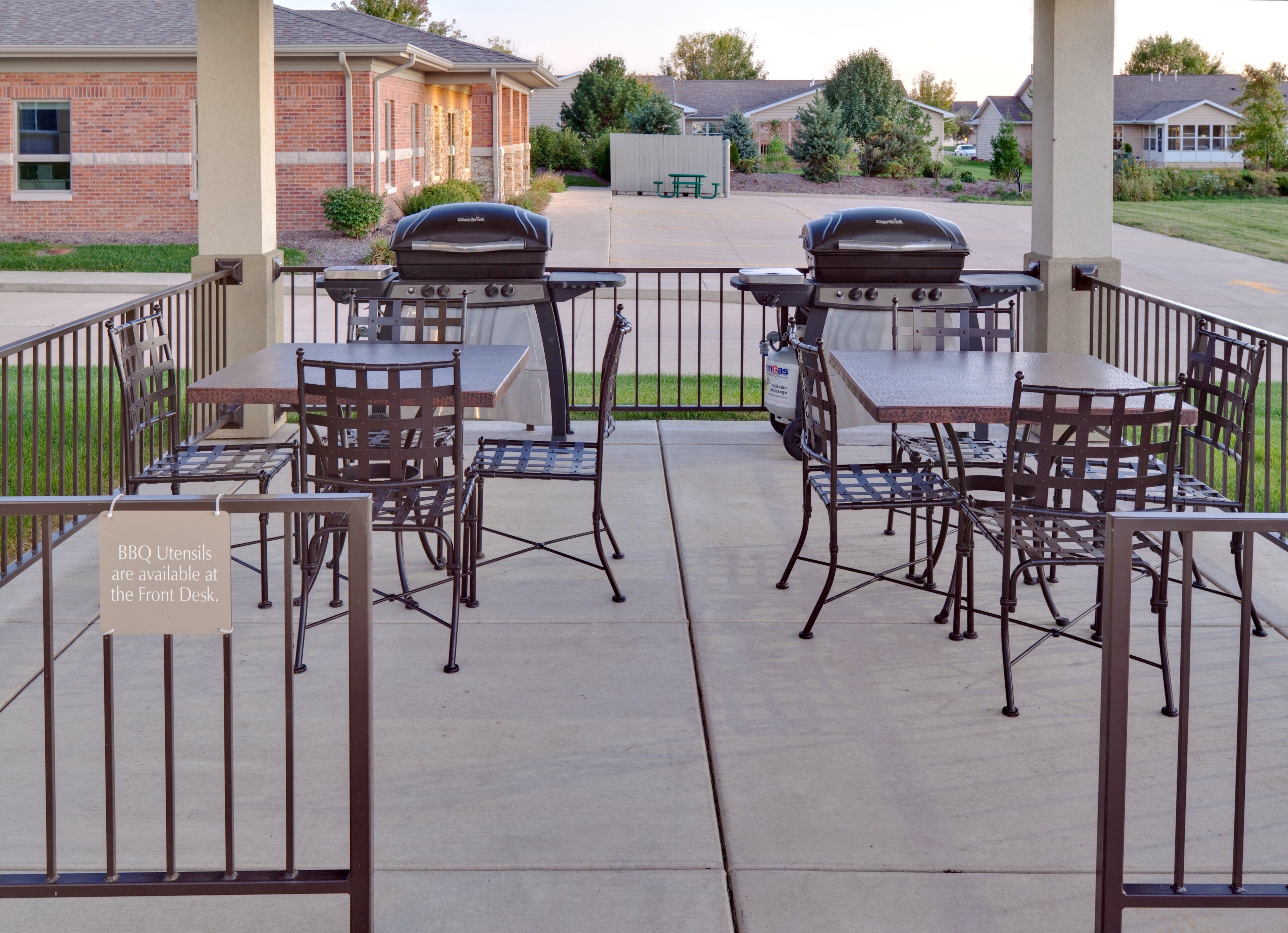 Un patio al aire libre con dos parrillas, una mesa y sillas.