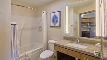 A modern bathroom with a bathtub, toilet, and sink.