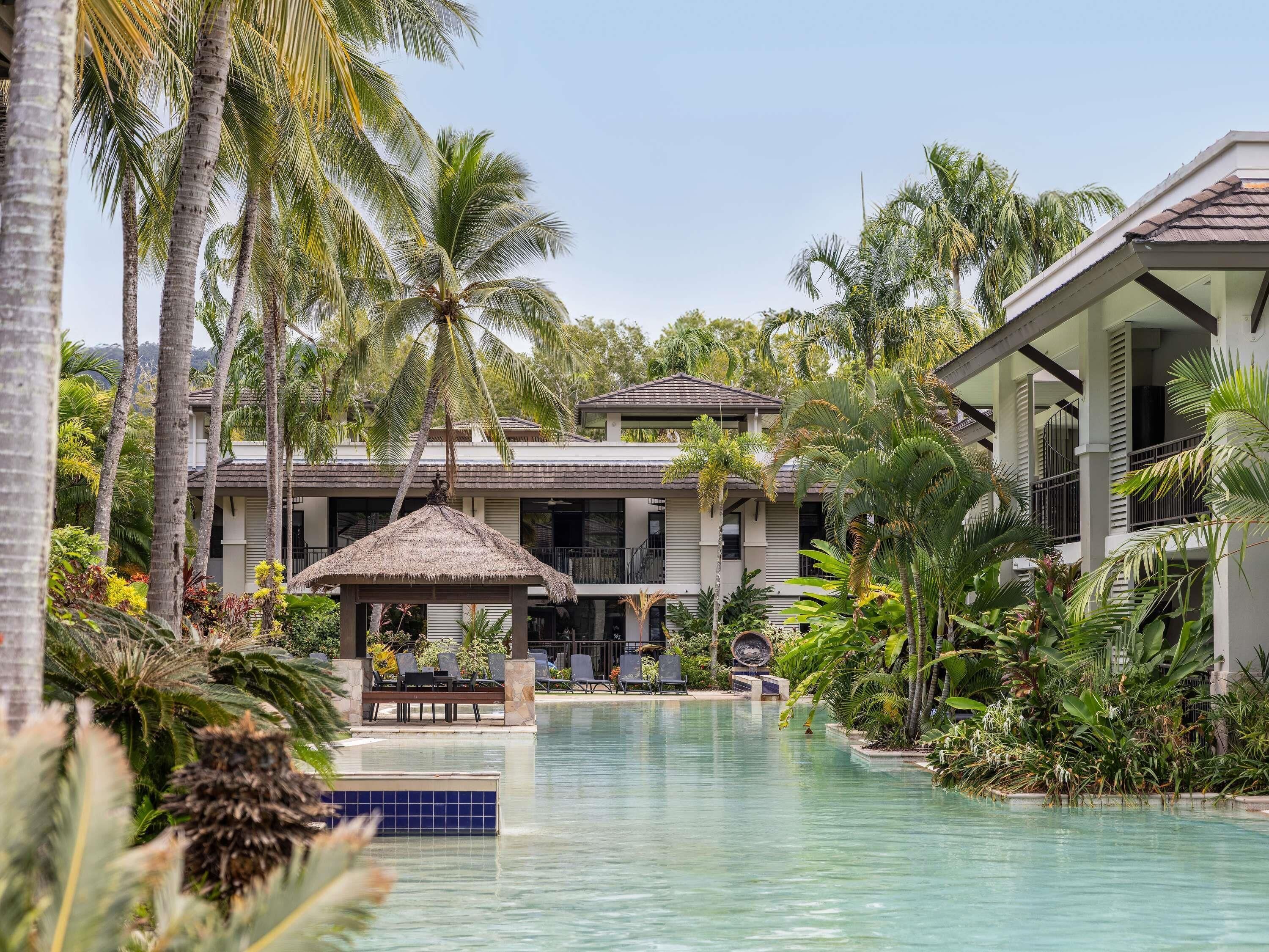 Una piscina al aire libre, sillones reclinables de piscina