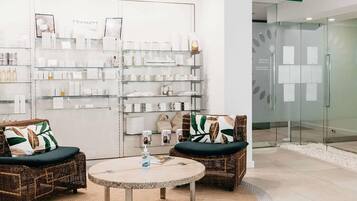 A modern interior with wicker furniture, a round table, and glass display shelves.