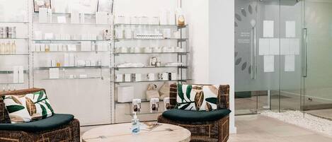 A modern interior with wicker furniture, a round table, and glass display shelves.