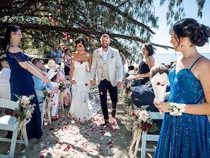 A wedding ceremony on a beach with white chairs and floral decorations. - Pullman Port Douglas Sea Temple Resort and Spa (Craiglie)