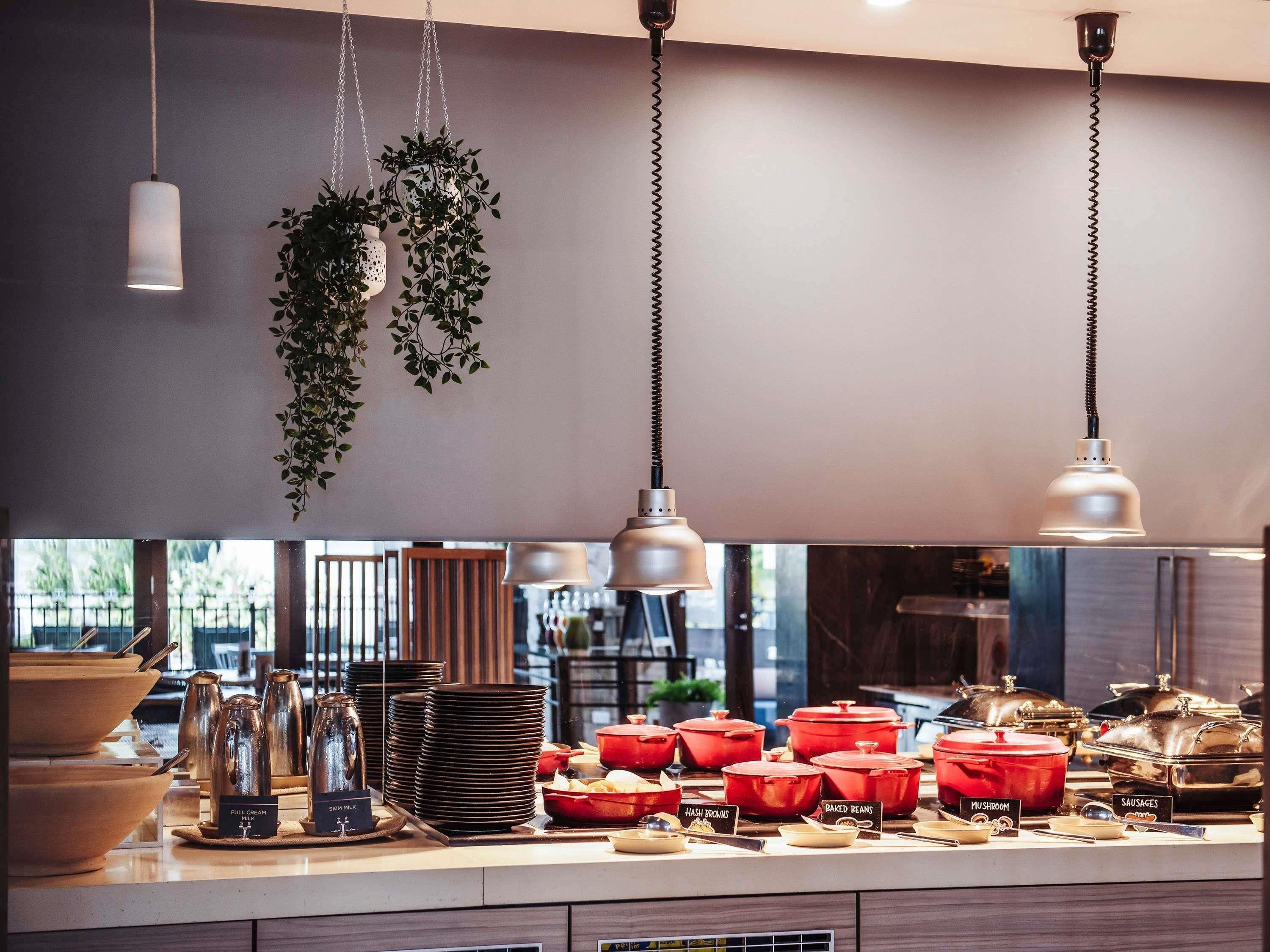A buffet setup with various food items and serving utensils.