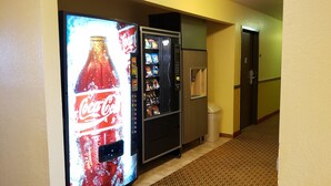 Un pasillo con una máquina expendedora de Coca-Cola y otra de aperitivos.