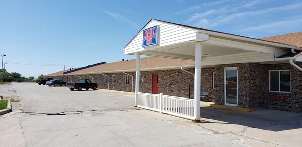 A motel with a covered parking area, a brick facade, and a sign indicating it is a family budget motel. - Family Budget Inn Bethany (Bethany)