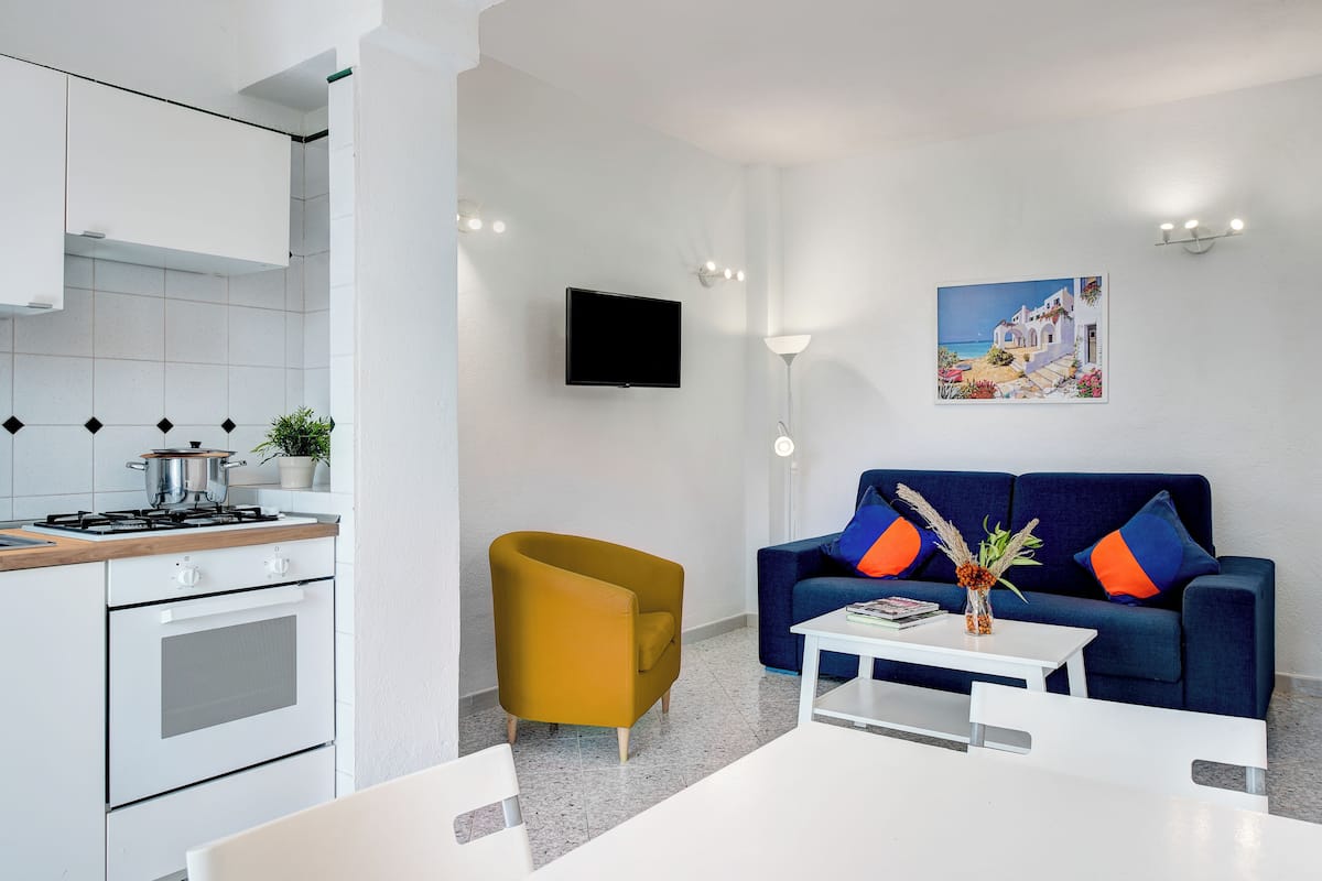 Ein modernes Wohnzimmer mit einer Couch, einem Couchtisch und einem Fernseher.