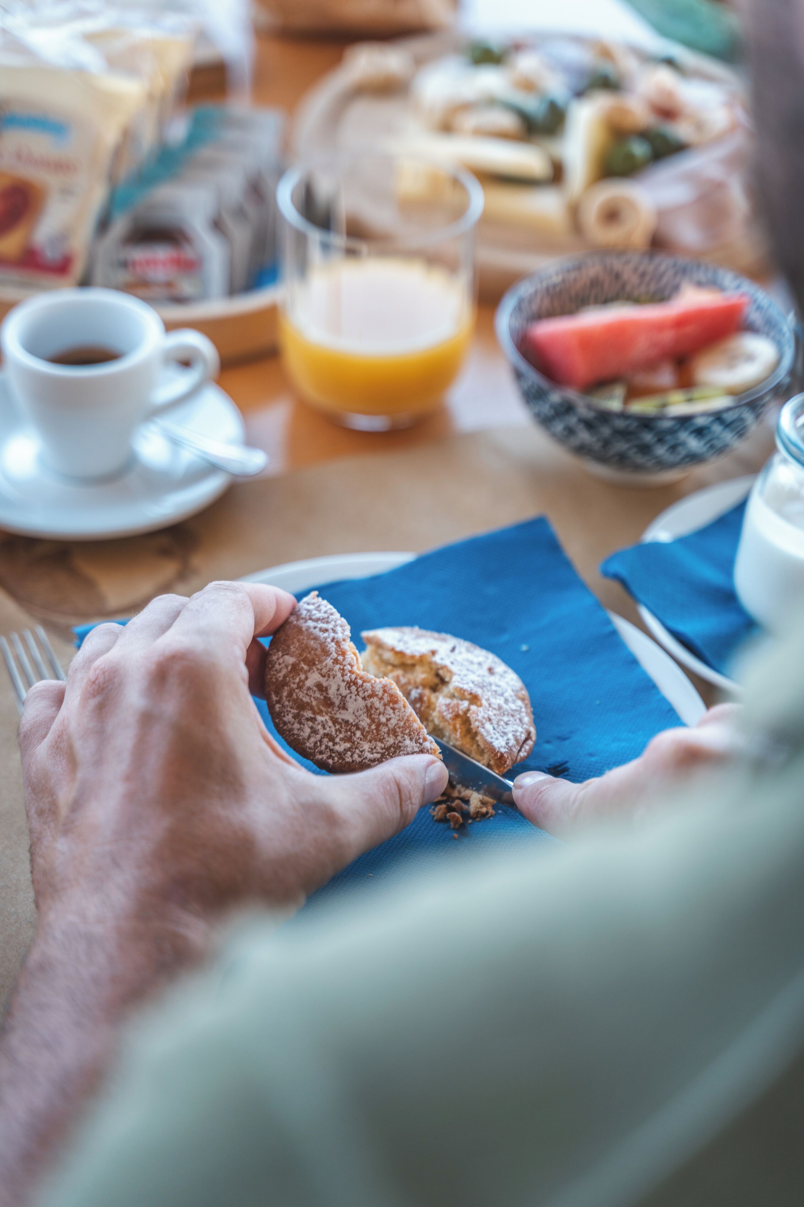 Une table mise pour le petit-déjeuner, avec une assiette de nourriture, un verre de jus d’orange et une tasse de café.