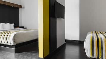 Una habitación de hotel moderna con una cama, una mesita de noche y un televisor de pantalla plana montado en la pared.
