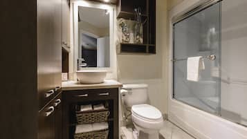 A modern bathroom with a vanity, toilet, and glass shower enclosure.