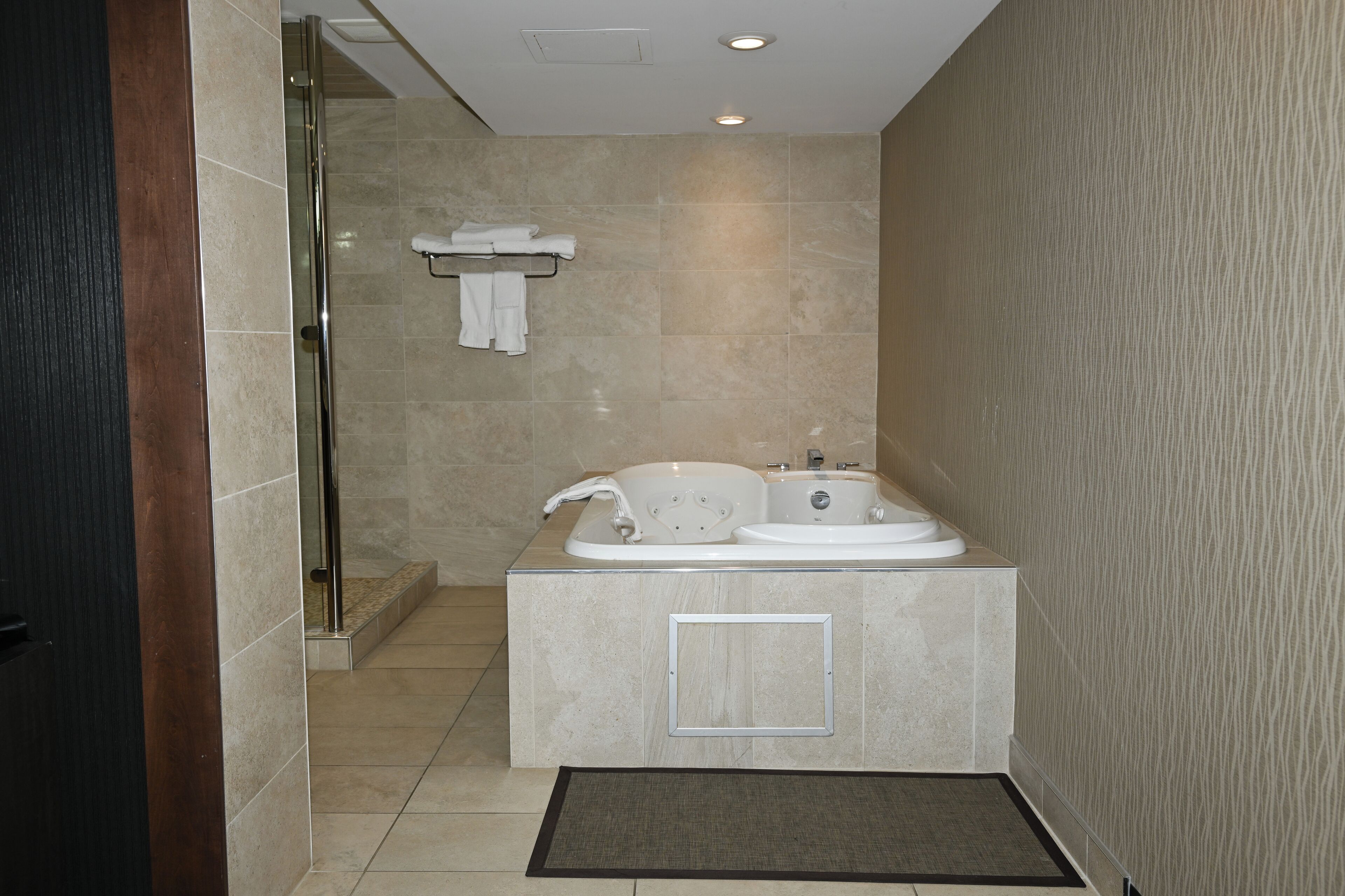 A modern bathroom with a glass shower enclosure, a bathtub, and a sink.