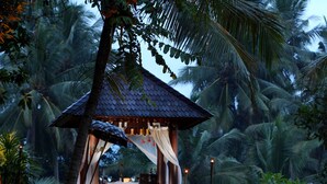 A tropical resort with a staircase leading to a gazebo, surrounded by palm trees and a pathway lit by candles. - FuramaXclusive Resort & Villas, Ubud (Mas)