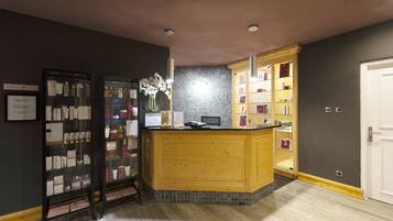 A reception area with a wooden counter, a glass display case, and a tiled backsplash.