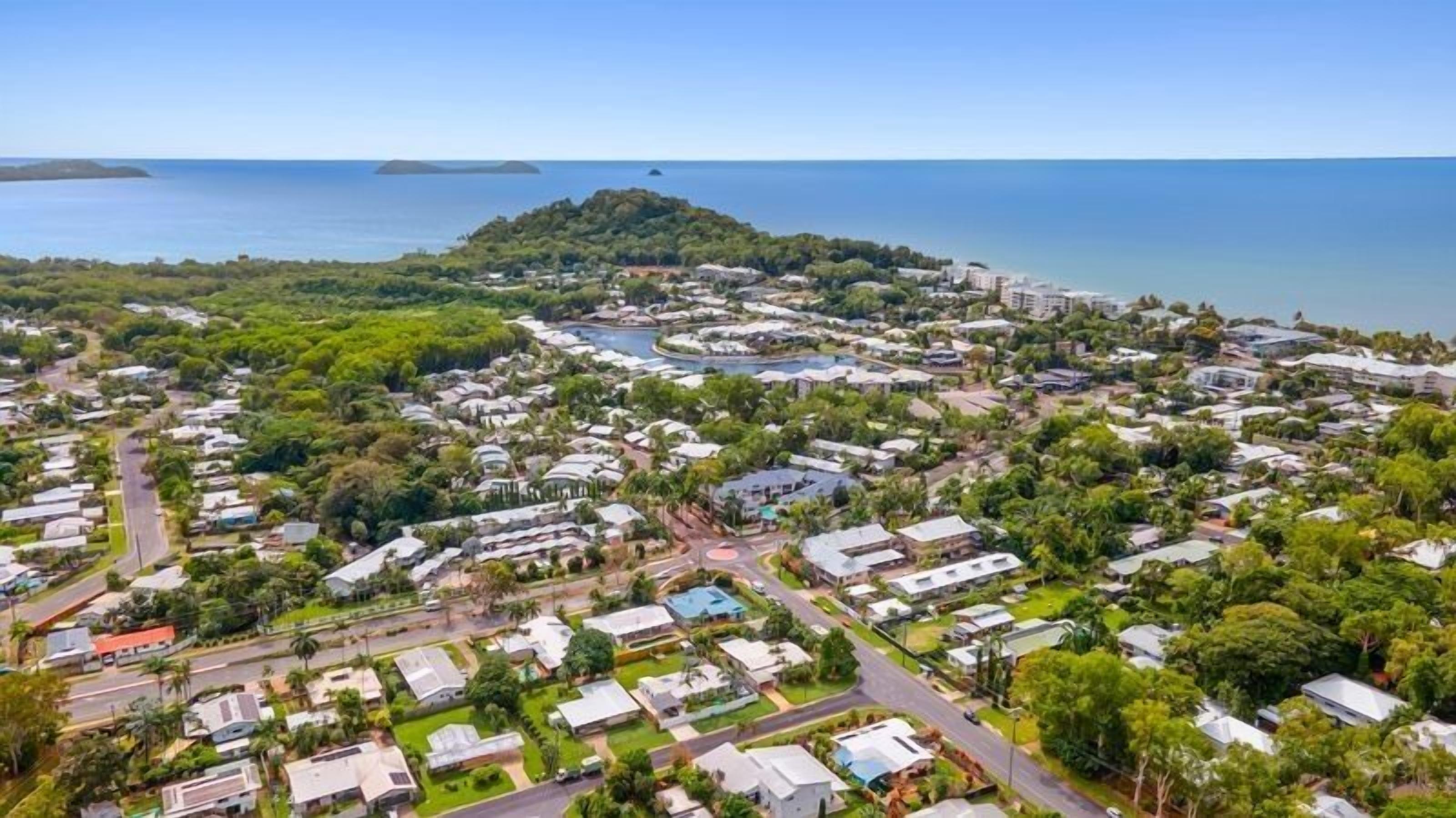 Vista aérea de una zona residencial costera con casas, carreteras y una extensión de agua.