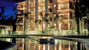 A multi-story hotel with balconies, a swimming pool, and palm trees. - Blue Lagoon Resort (Trinity Beach)