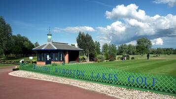 A golf course entrance with a sign reading "Welcome to Wyboron Lakes Golf".