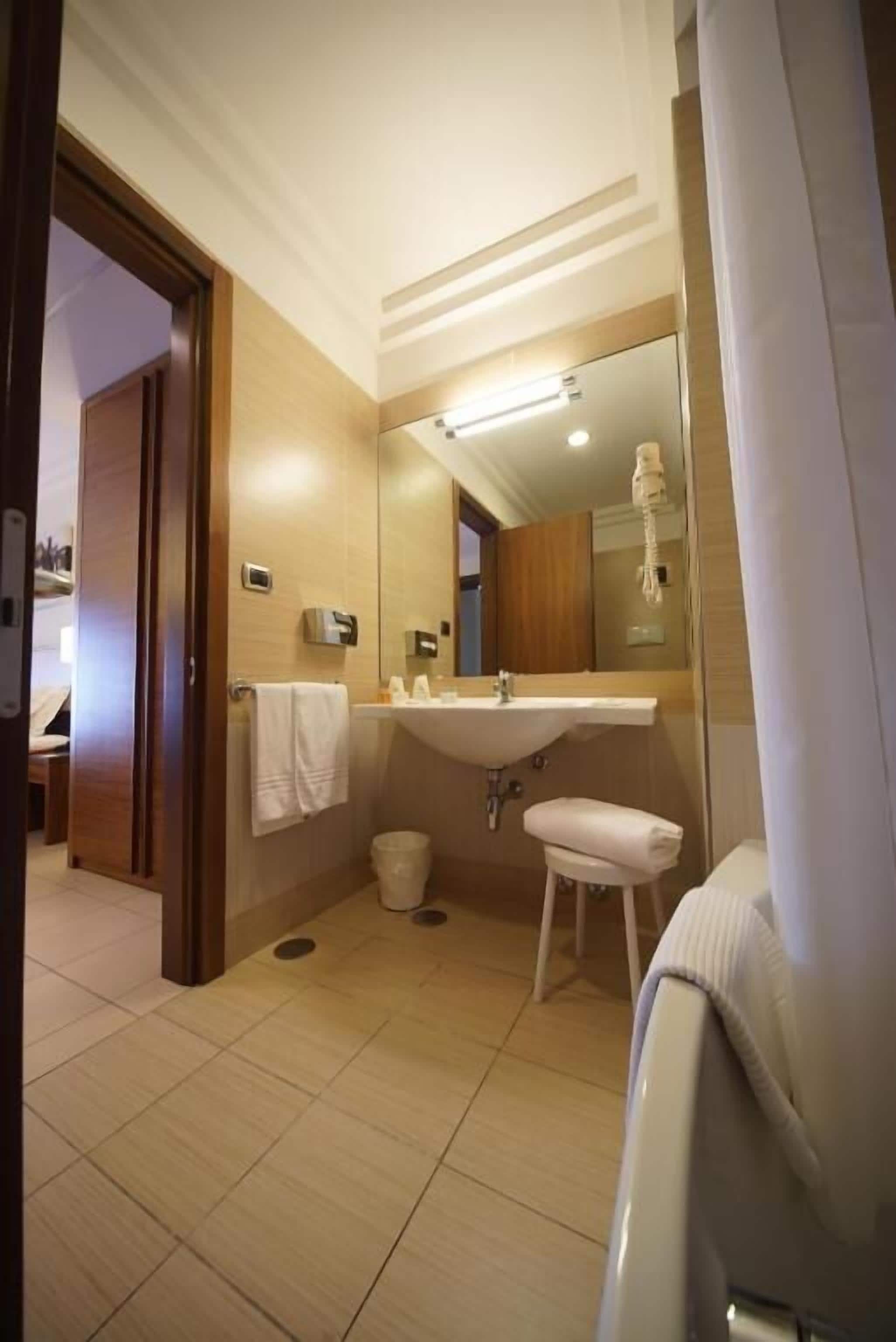 Une salle de bain moderne avec un lavabo, un miroir et un porte-serviettes.