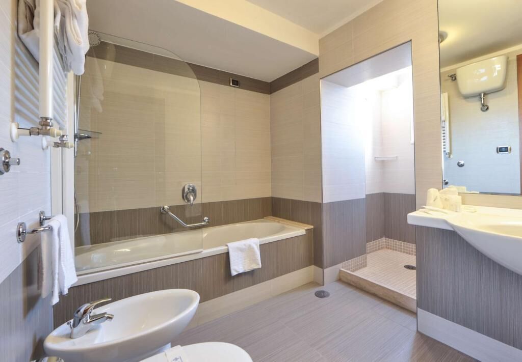 Un baño moderno con bañera, lavamanos y zona de ducha.