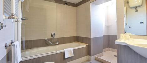 Un baño moderno con bañera, lavamanos y zona de ducha.