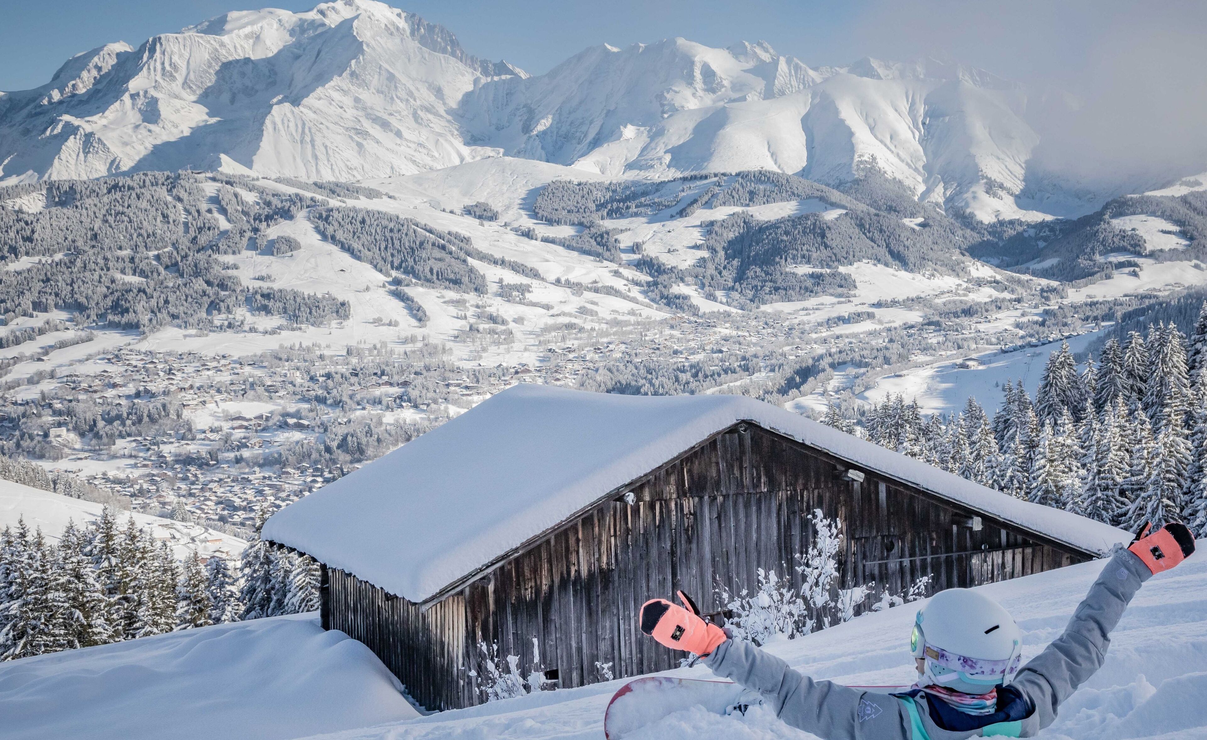 A snow-covered mountain landscape with a wooden cabin in the foreground.
