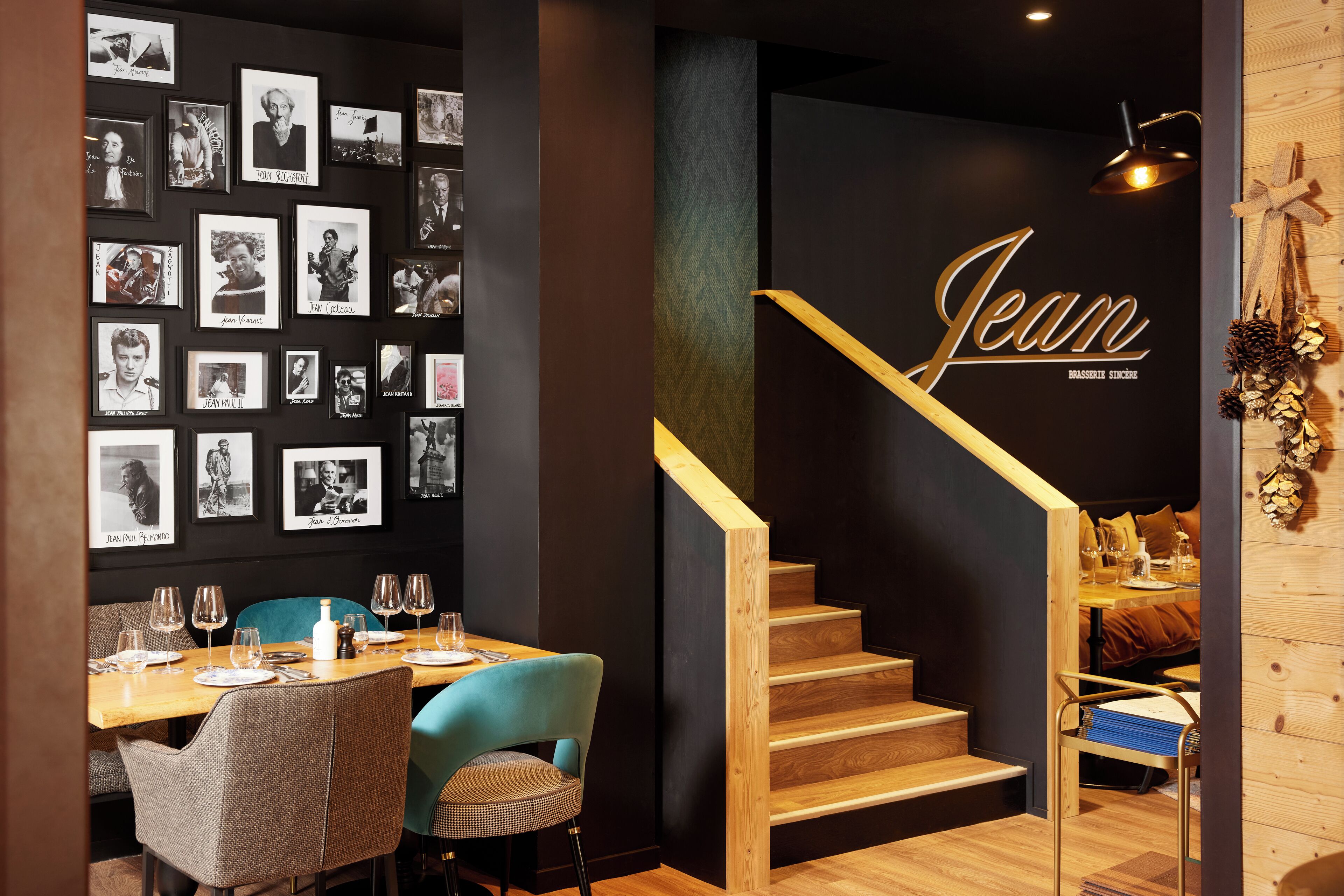 Un comedor con una escalera de madera, una pared con fotografías enmarcadas y un letrero que dice "Jean".