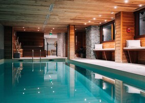 Una piscina techada, abierta desde las 10:00 hasta las 21:00, sombrillas