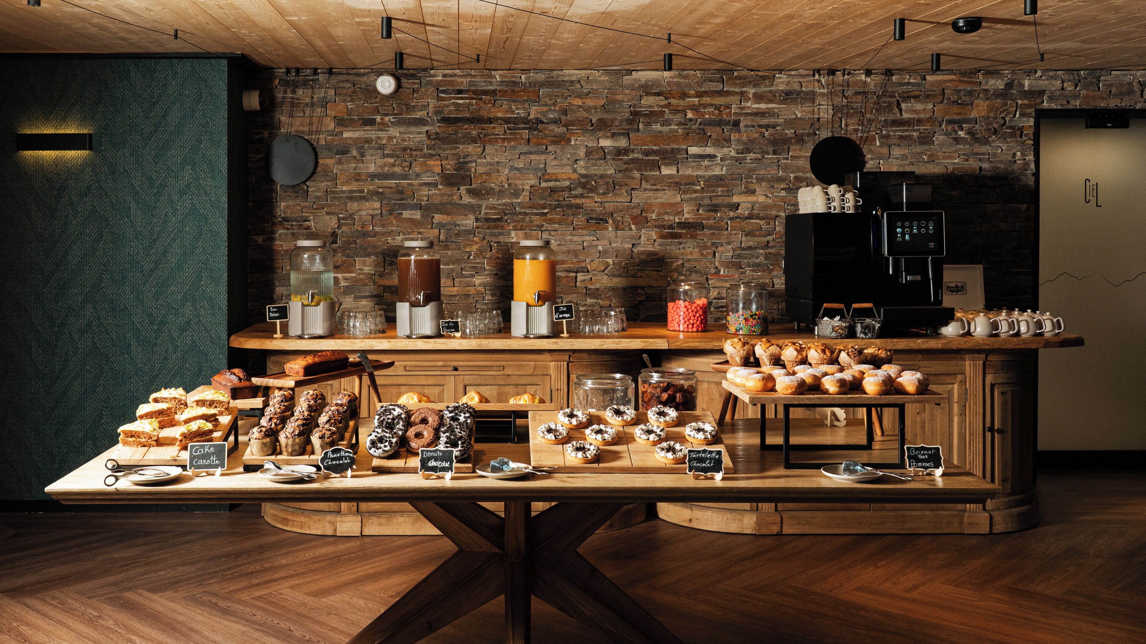 Buffet de café da manhã com diversos pães e bebidas.