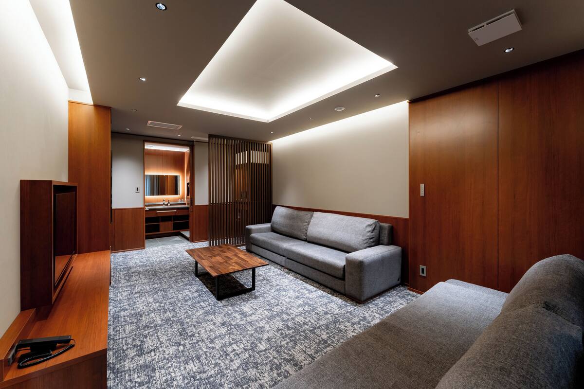 A modern living room with a sofa, a coffee table, and a wooden cabinet.