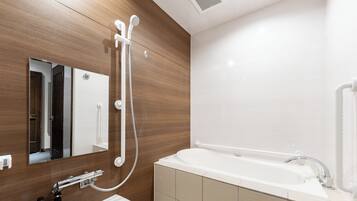 Un baño moderno con un espejo grande, una bañera y una ducha.
