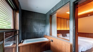 Un baño moderno con una bañera de madera, un espejo grande y una zona de ducha separada.