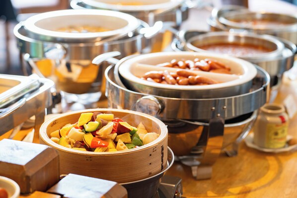 A buffet with various food items in metal and wooden bowls. - Hotel Sierra Resort Hakuba (Hakuba)