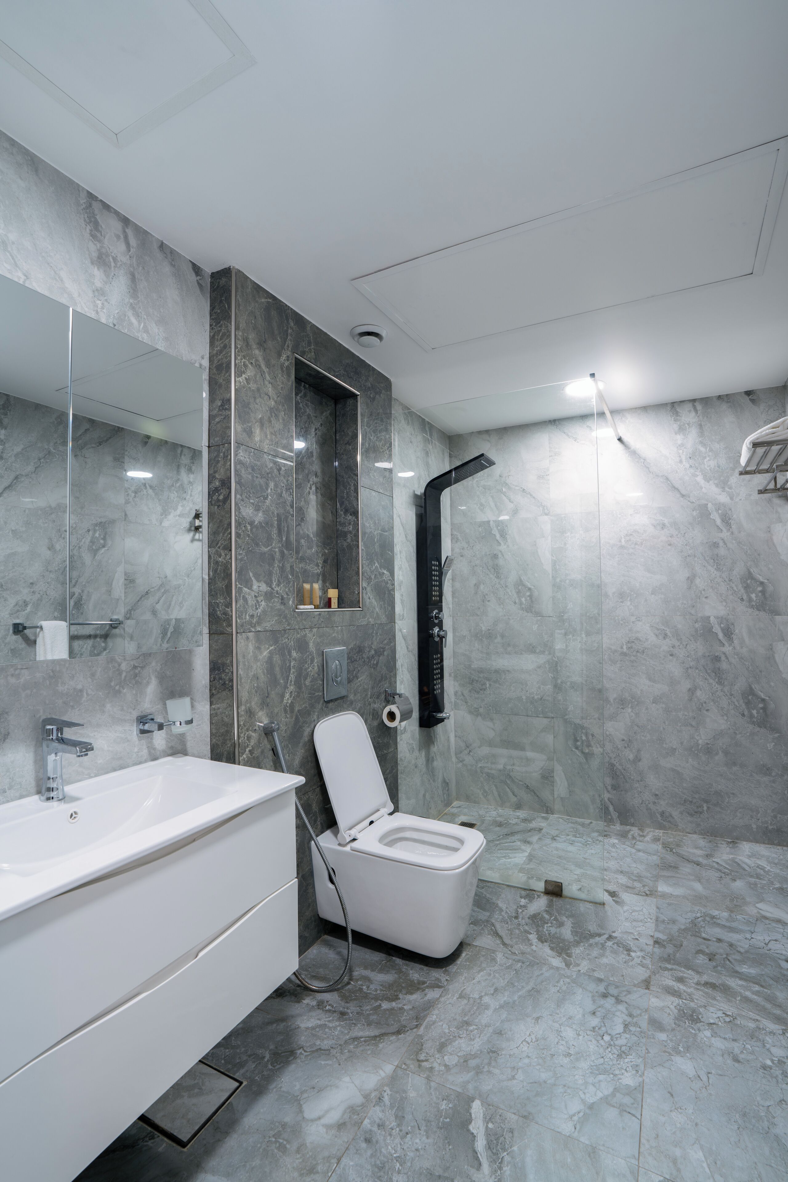 A modern bathroom with a white sink, mirror, and shower.