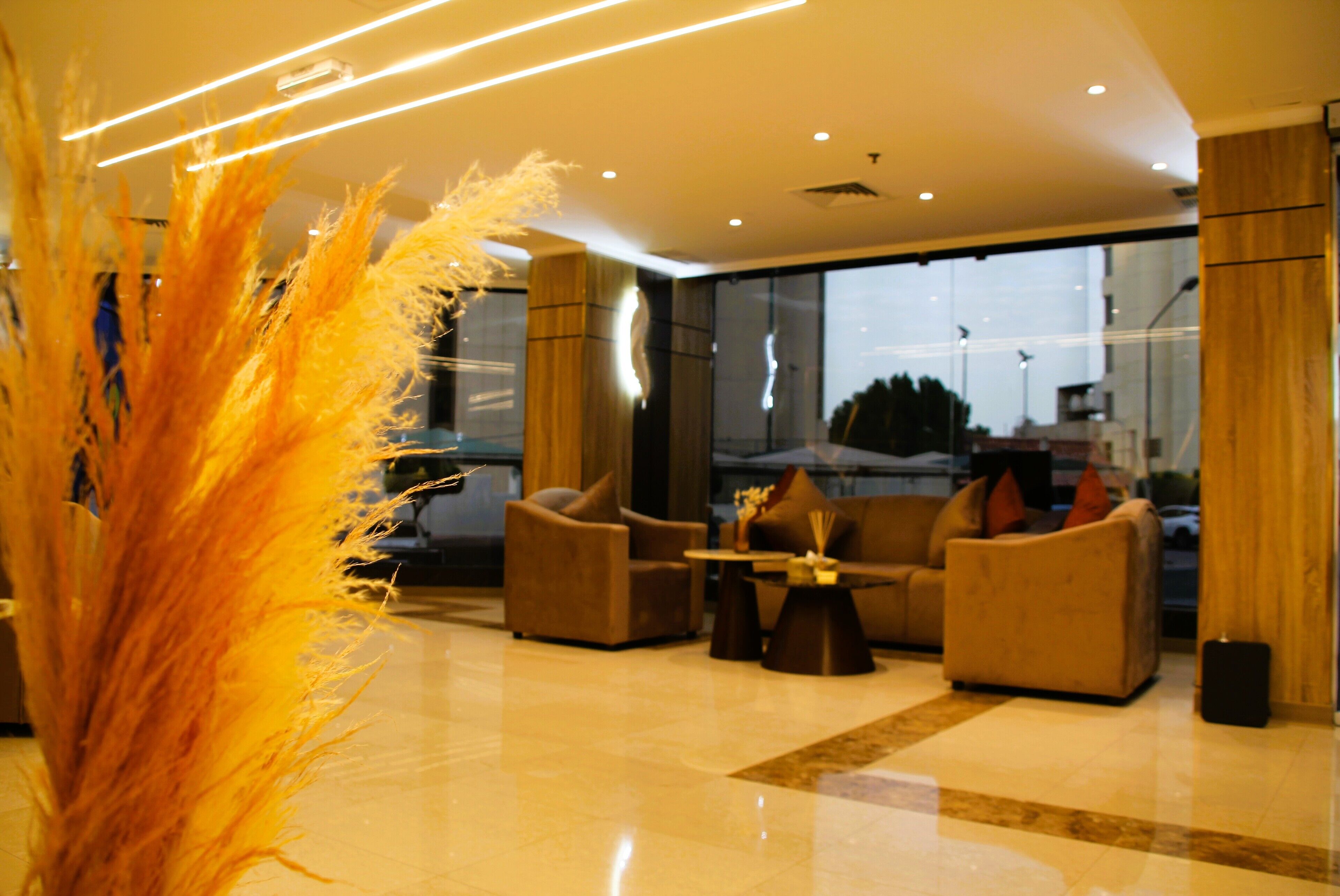 A modern lobby with sofas, a coffee table, and a decorative plant.