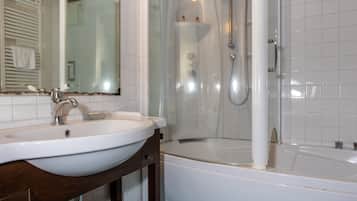 A bathroom with a white sink, a mirror, a shower, and a bathtub.