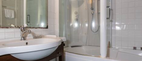 Ein Badezimmer mit Waschbecken, Spiegel, Dusche und Badewanne.