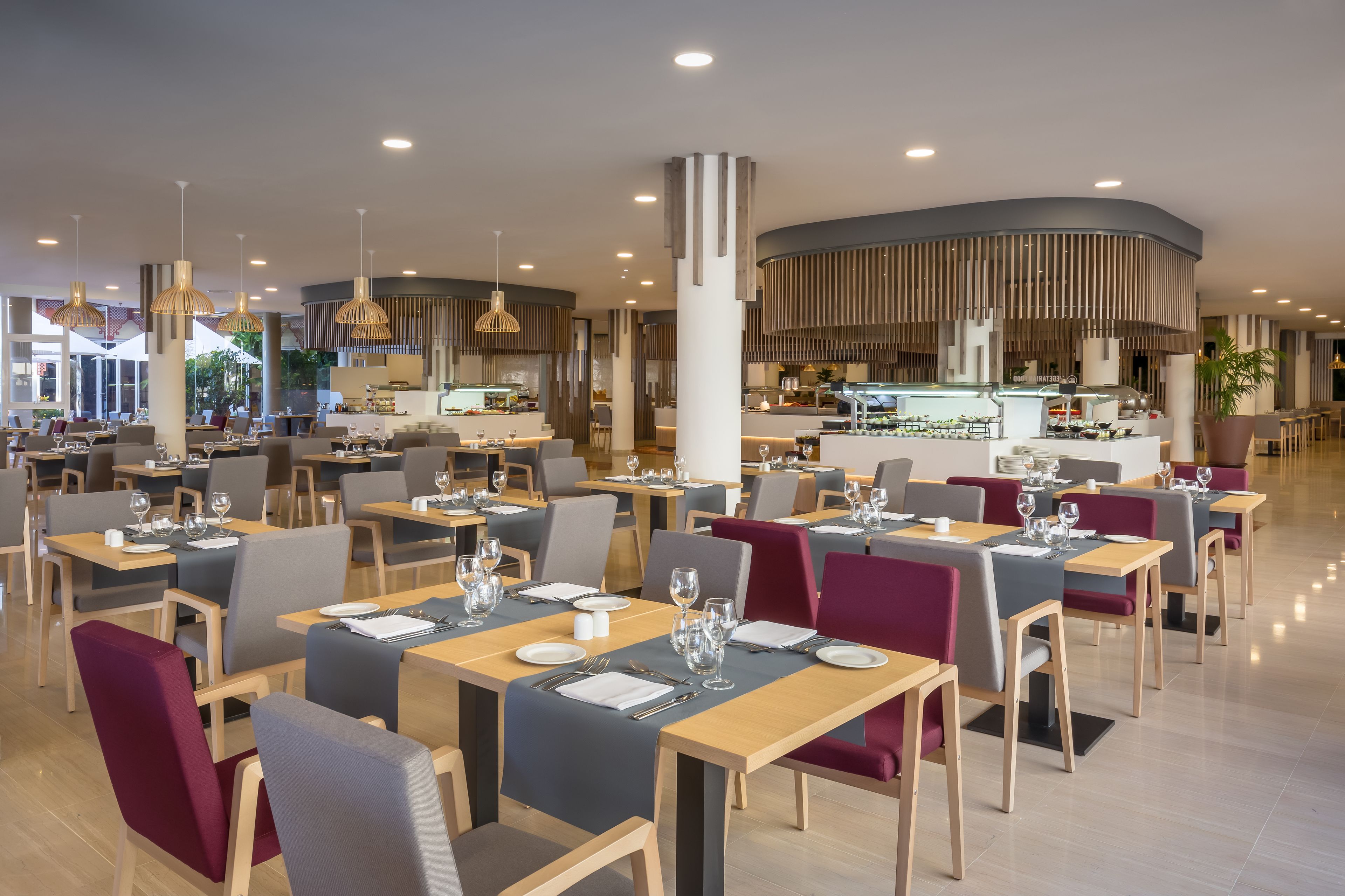 A modern restaurant with multiple dining areas, each with tables set for two.