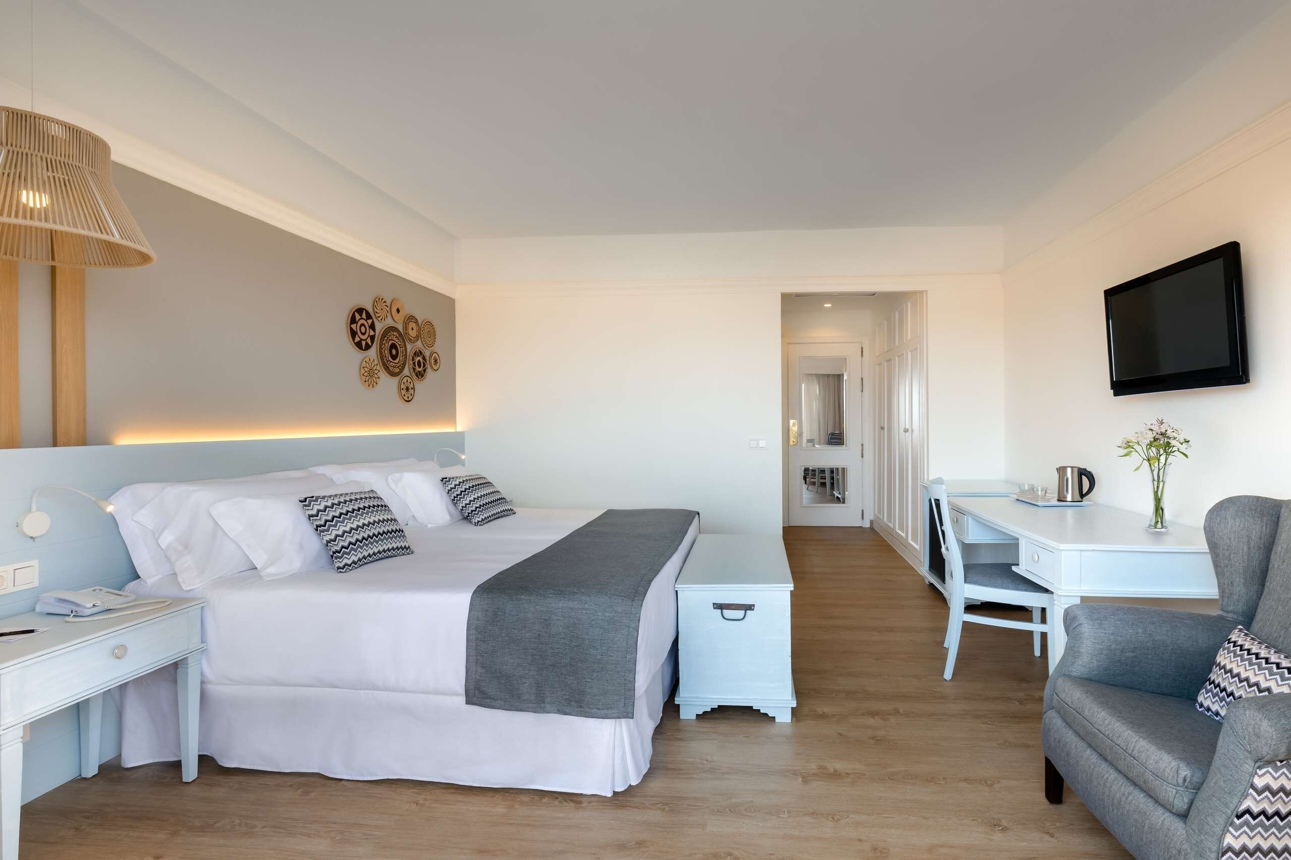 Een moderne hotelkamer met een groot bed, een bureau, een stoel en een televisie.