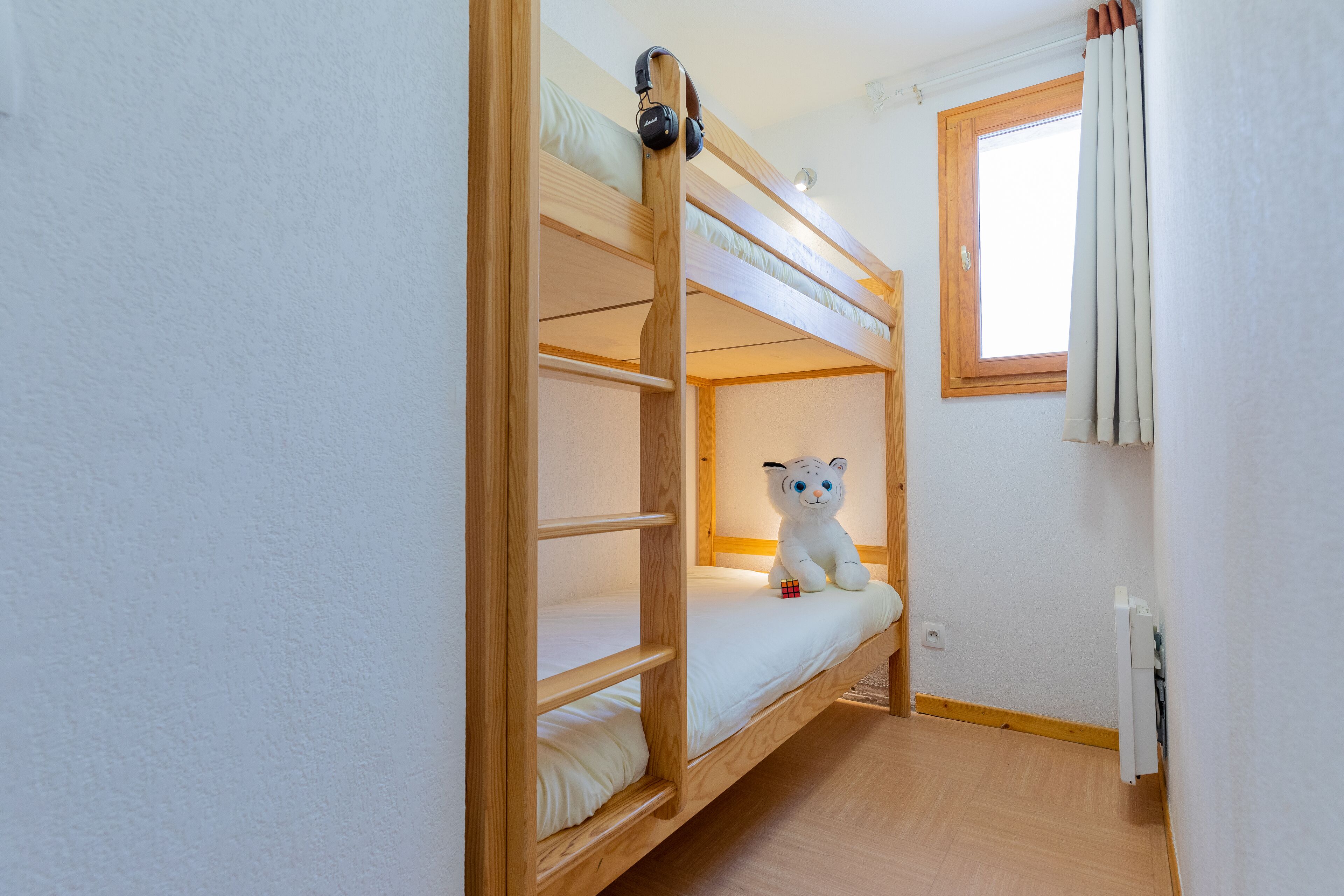 Habitación con literas y un peluche en la cama inferior.