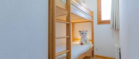 Habitación con literas y un peluche en la cama inferior.