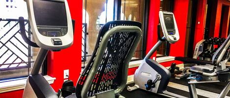 A gym with exercise equipment and red walls.