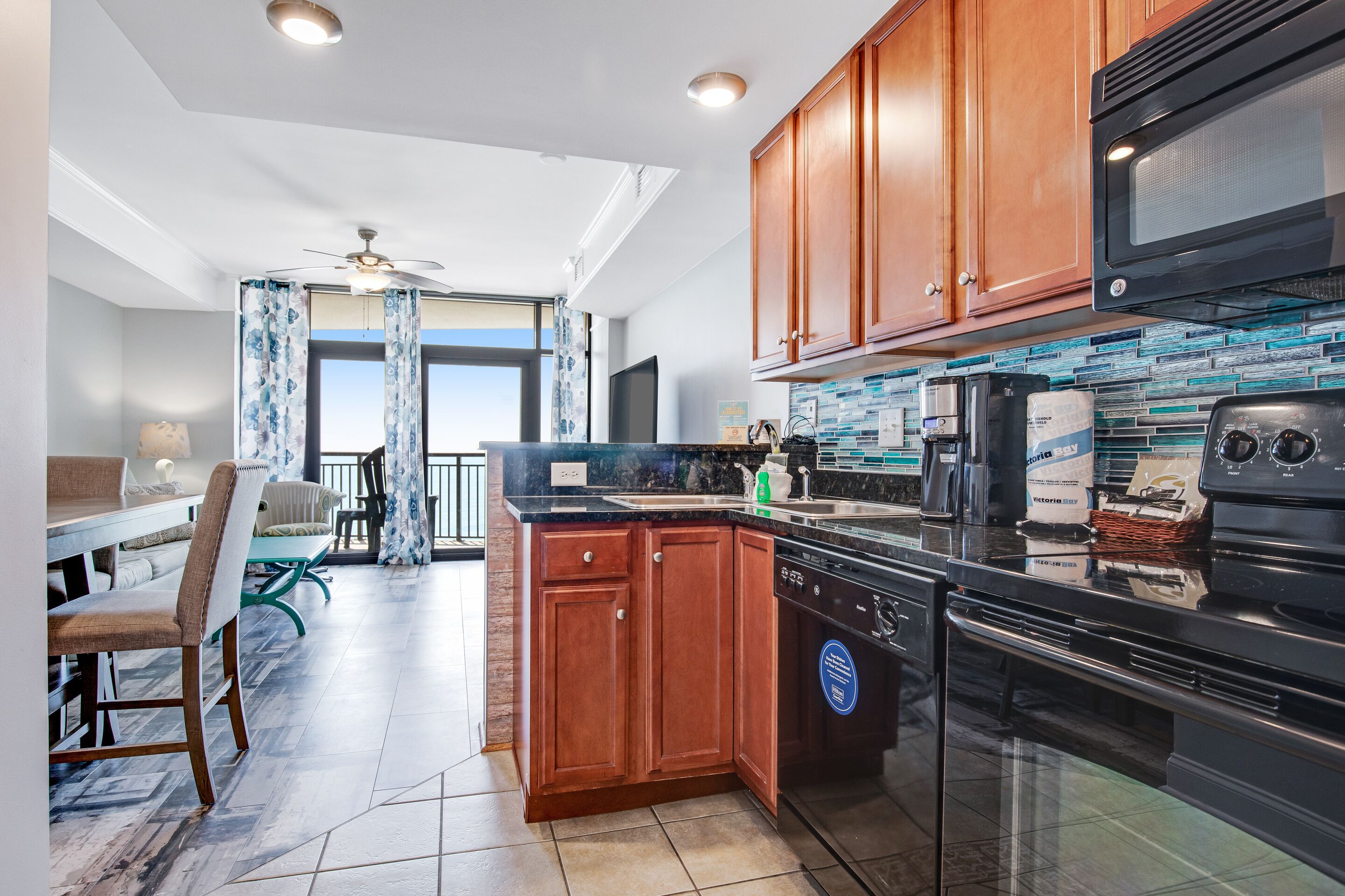 A modern kitchen with wooden cabinets, a black microwave, and a dishwasher.