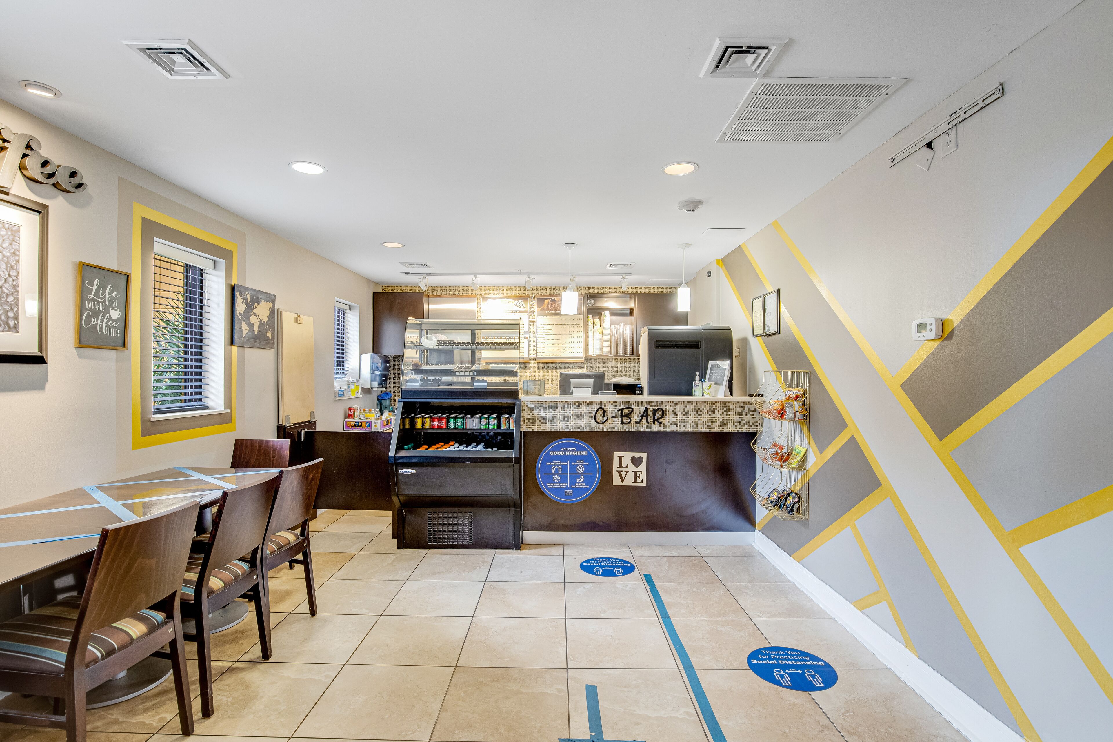 A restaurant with a counter, chairs, and a dining area.