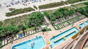 Un complexe hôtelier doté d’une piscine, d’une plage et de chaises longues.