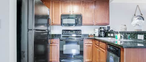 Una cocina moderna con armarios de madera, electrodomésticos de acero inoxidable y lavavajillas integrado.